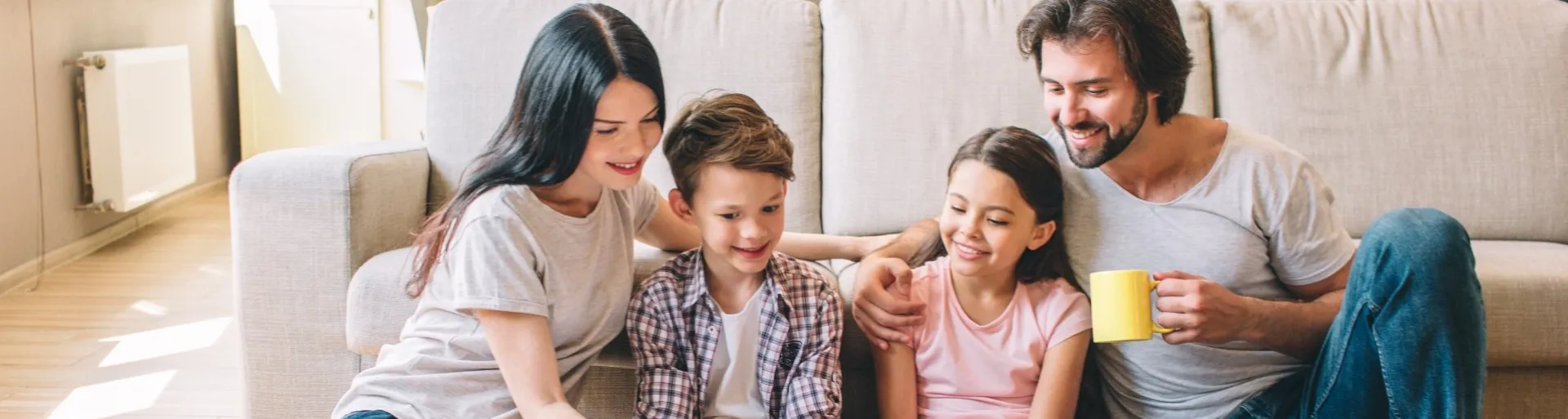 Familie, 2 ouders, 2 kinderen lezen samen in een boek 